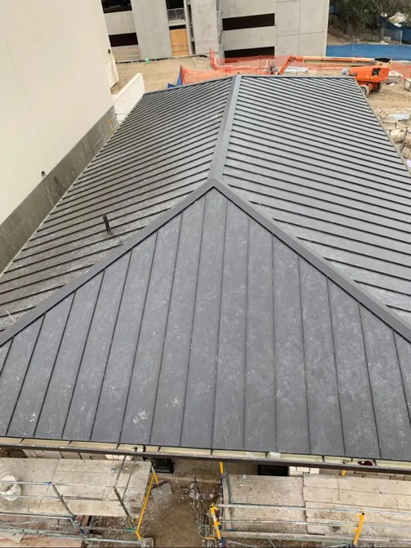 Commercial metal roof construction with crane equipment in Ocoee